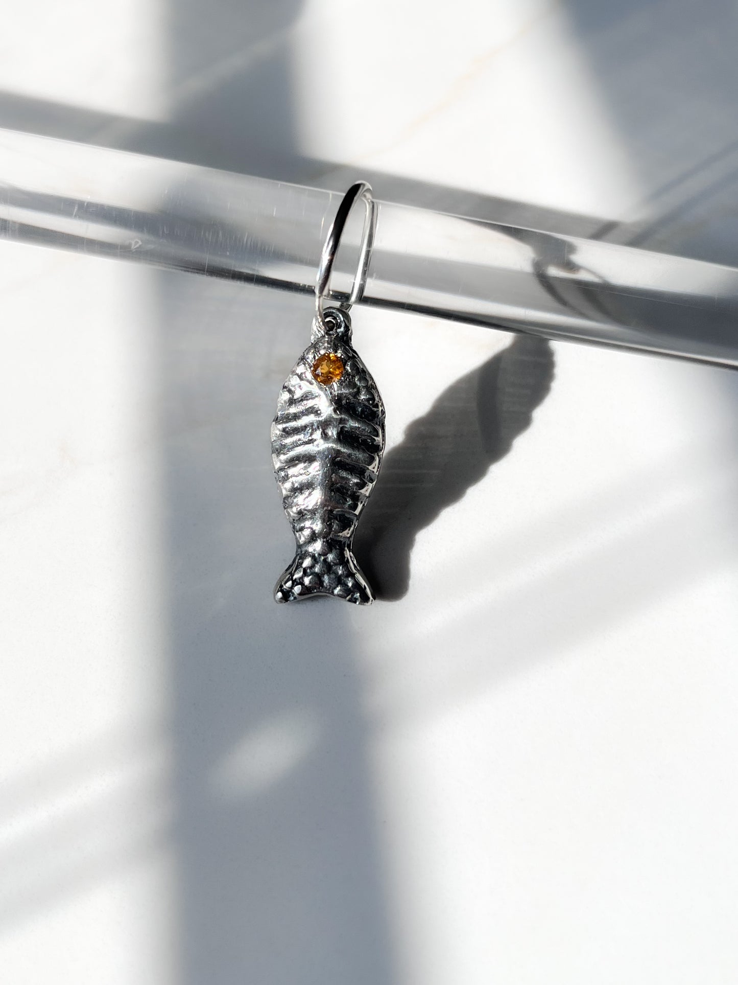 Bone fish charm with orange tourmaline gemstone on endless hoop